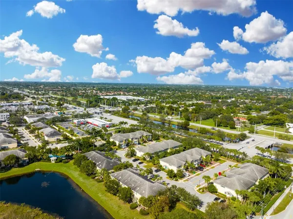 an aerial view of a city with lots of residential buildings ocean and mountain view in back