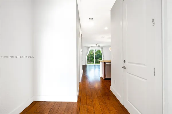 a view of a hallway with wooden floor