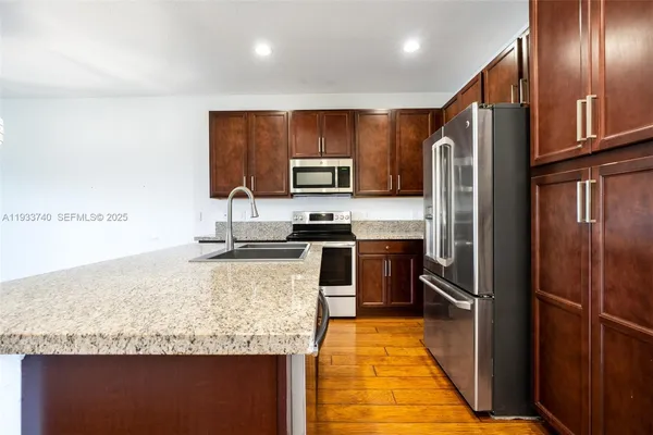 a kitchen with granite countertop stainless steel appliances and refrigerator