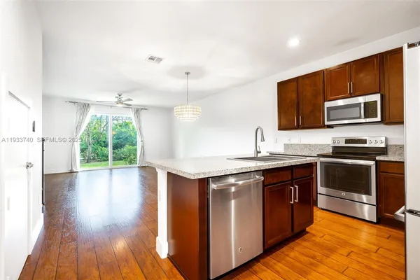 a kitchen with stainless steel appliances granite countertop a stove a sink and a microwave