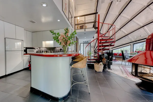 a kitchen with stainless steel appliances kitchen island granite countertop a sink a stove and a wooden floors