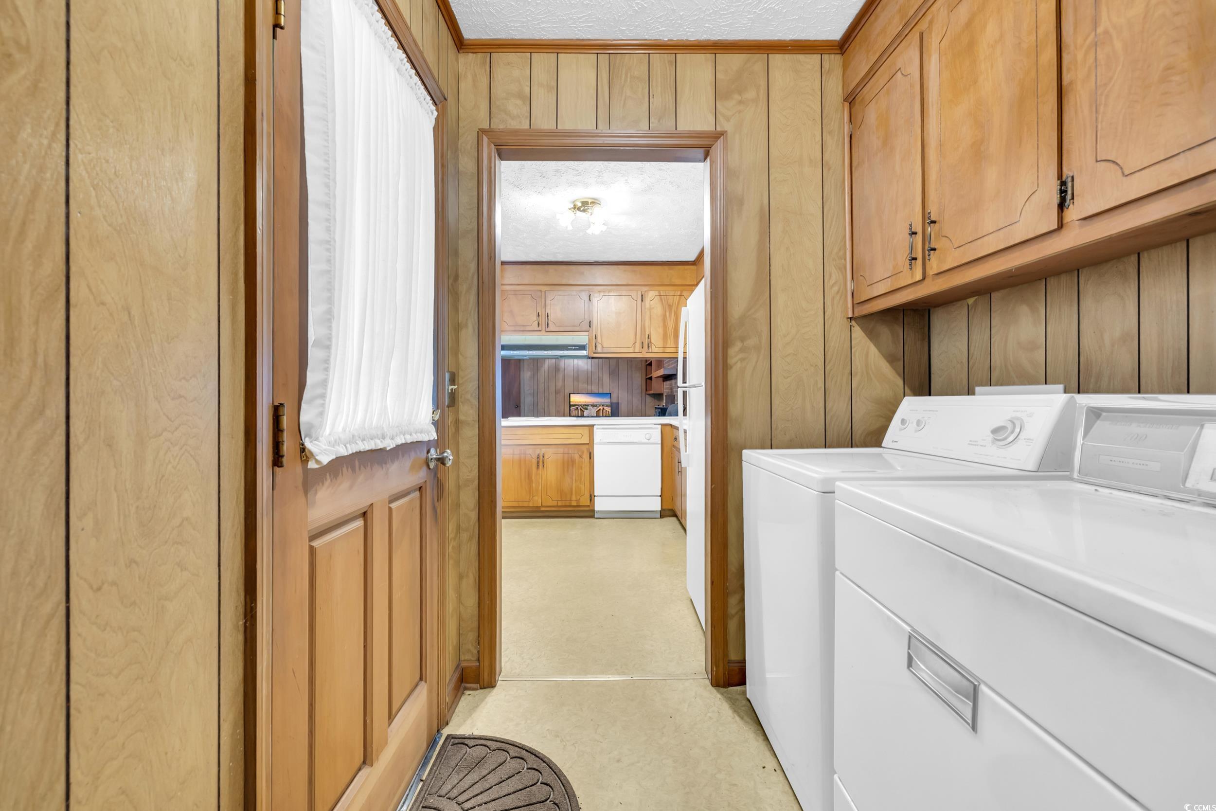 1928 Emery Road Loris, SC 29569 - Photo 17 of 24 Laundry room featuring wood walls, washer and dryer, and cabinet space
