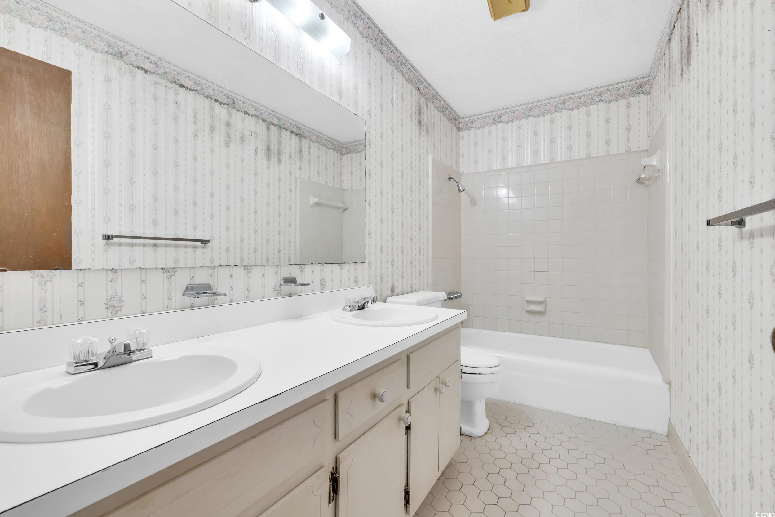 1928 Emery Road Loris, SC 29569 - Photo 9 of 24 Bathroom with wallpapered walls, shower / bath combination, double vanity, and light tile patterned flooring