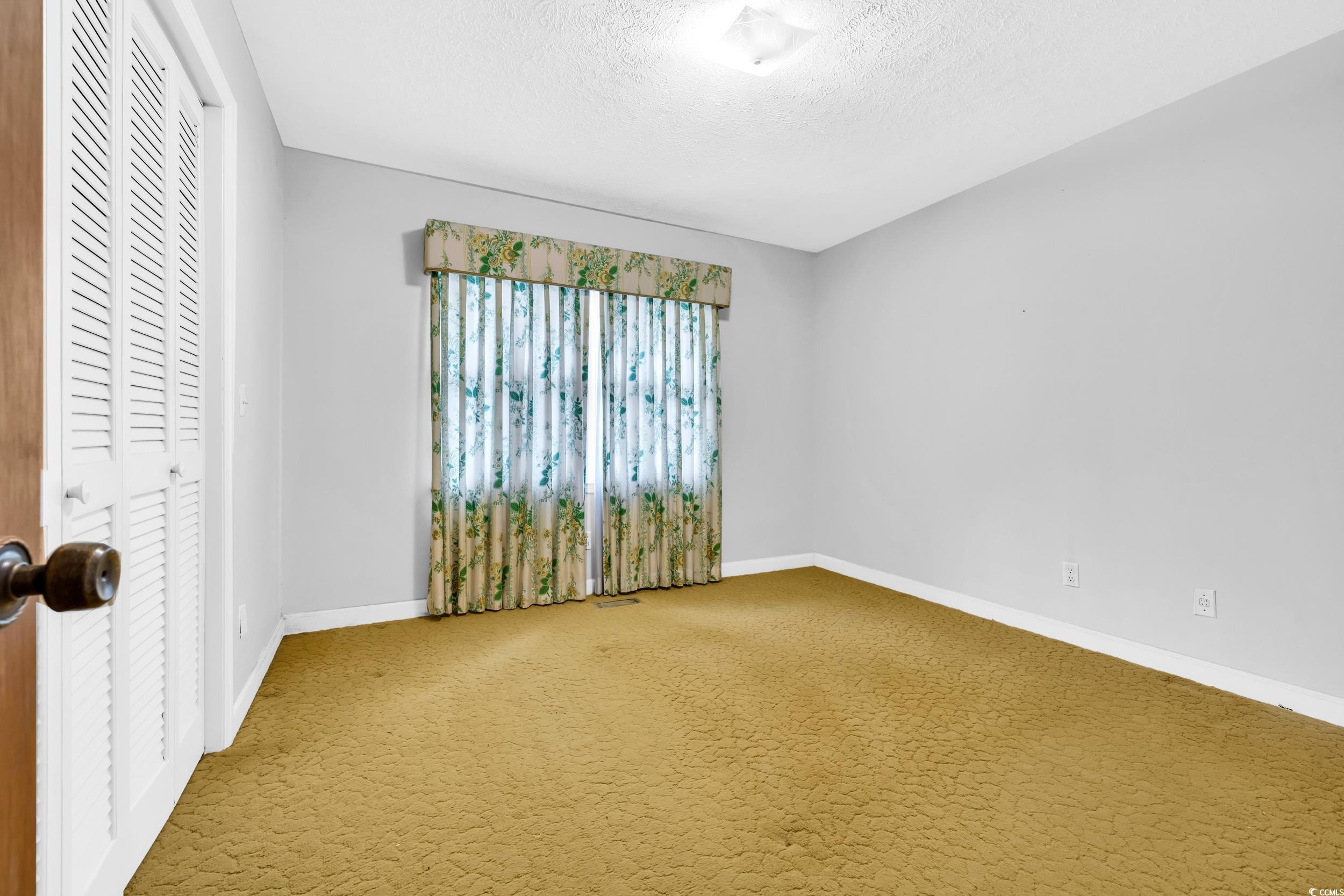 1928 Emery Road Loris, SC 29569 - Photo 10 of 24 Carpeted spare room featuring a textured ceiling and baseboards