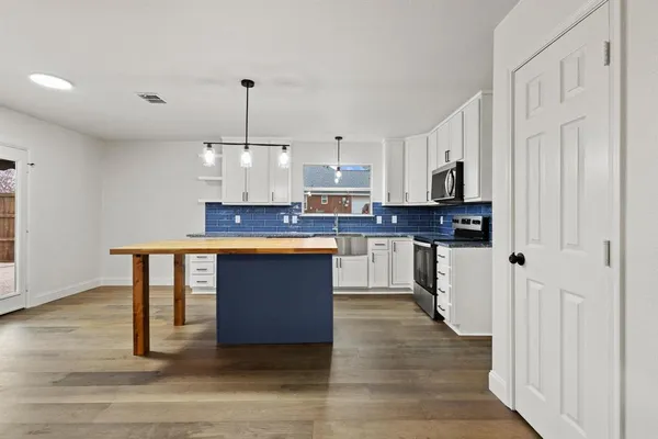 a kitchen with stainless steel appliances granite countertop a stove a sink and a refrigerator