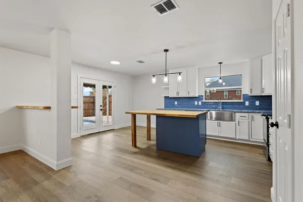 a large kitchen with cabinets wooden floor and stainless steel appliances