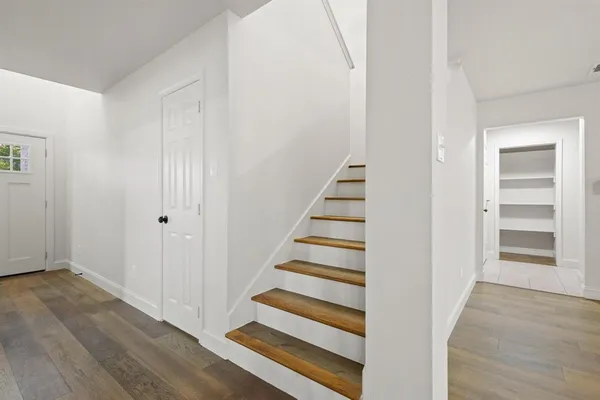 a view of a hallway with wooden floor and entryway