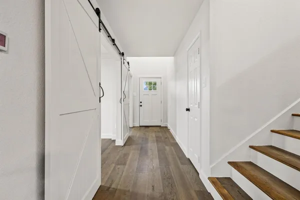 a view of a hallway with wooden floor and entryway