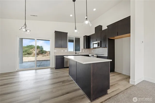 a large kitchen with kitchen island a sink stainless steel appliances and cabinets