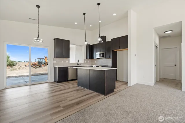 a large kitchen with kitchen island a sink stainless steel appliances and cabinets