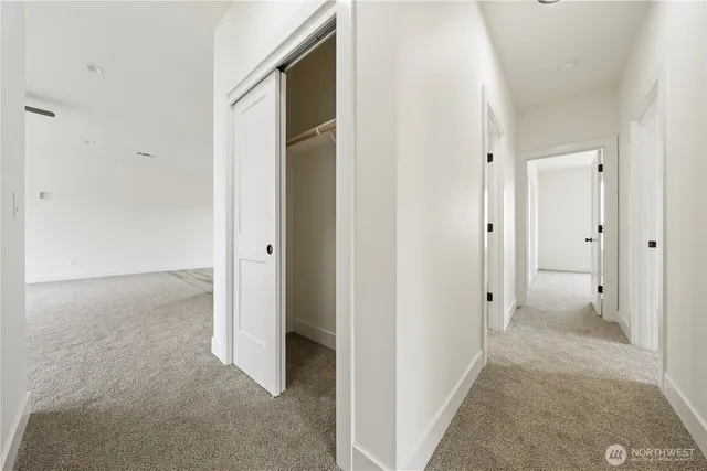 a view of a hallway with closet and wooden floor