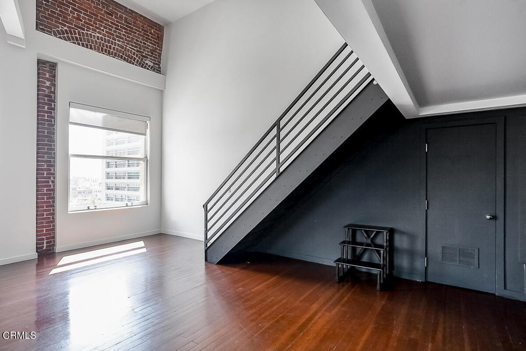 257 South Spring Street, Unit PHE Los Angeles, CA 90012 - Photo 7 of 29 an entryway with wooden floor and stairs