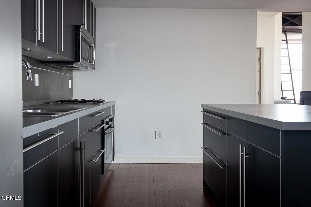 257 South Spring Street, Unit PHE Los Angeles, CA 90012 - Photo 9 of 29 a kitchen with a sink stove and microwave