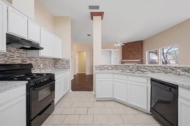 a kitchen with granite countertop a stove and a sink