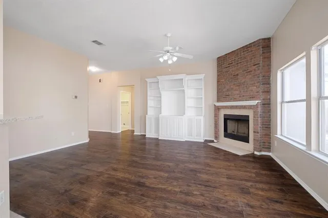 an empty room with windows and fireplace