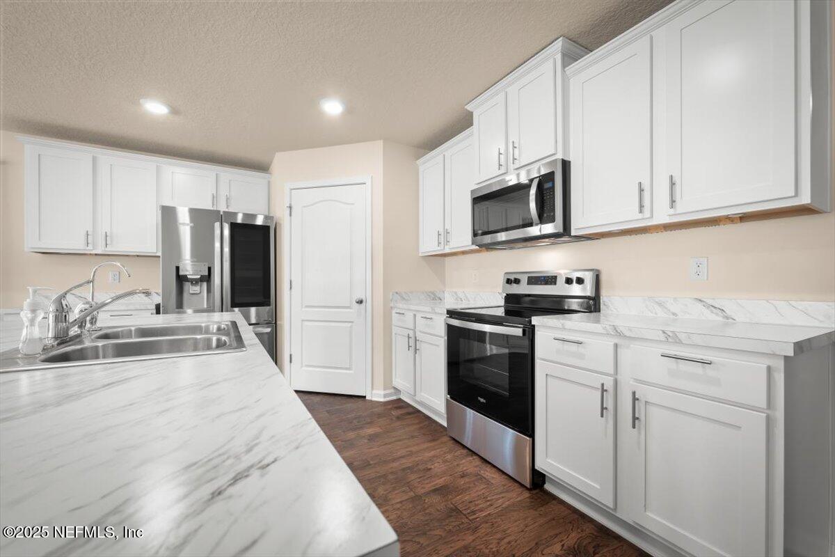 2080 Denton Trace Green Cove Springs, FL 32043 - Photo 13 of 32 a kitchen with granite countertop a refrigerator stove top oven and sink