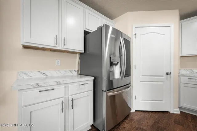 a kitchen with stainless steel appliances white cabinets and a refrigerator