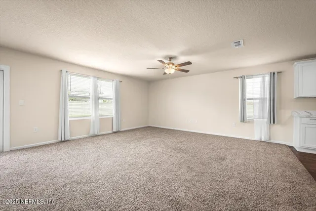 a view of a livingroom and a kitchen with furniture and chandelier