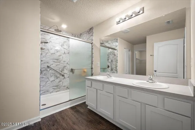 a bathroom with a granite countertop toilet a sink and a mirror