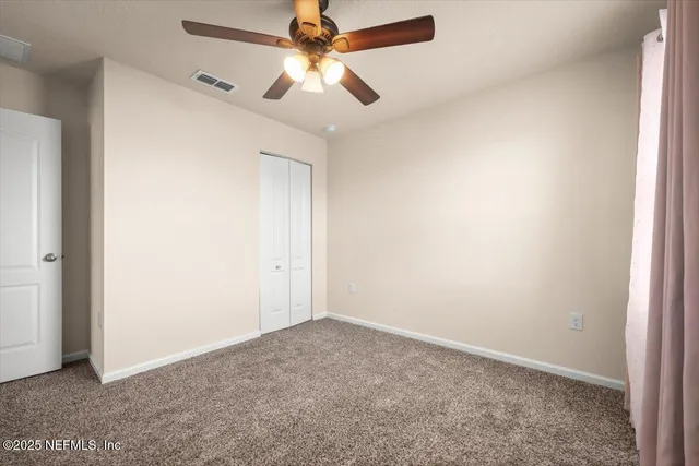 an empty room with a fan and a fan