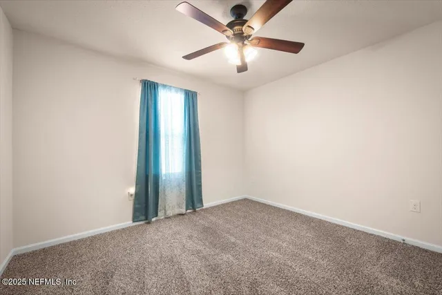 an empty room with chandelier fan