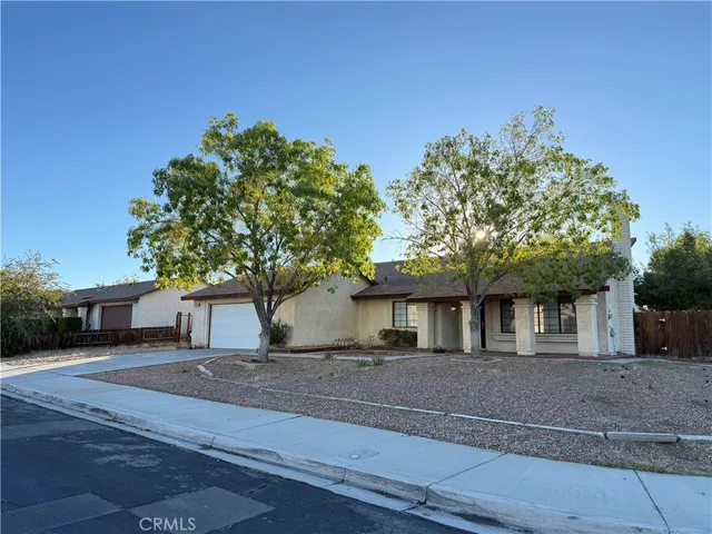 a front view of a house with a tree