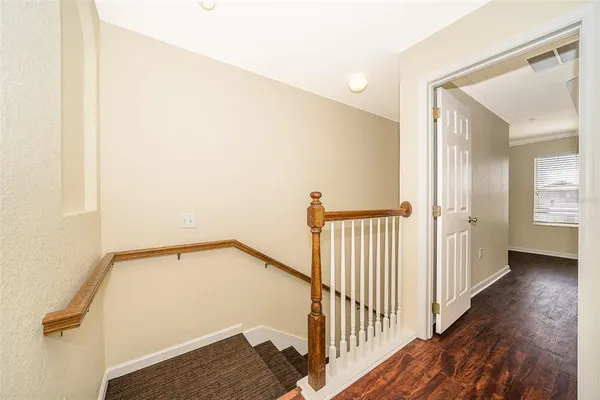 a view of a hallway with wooden floor and staircase