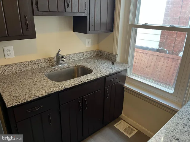 a kitchen with granite countertop a sink and a window