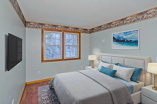 a bedroom with a bed and a painting on the wall