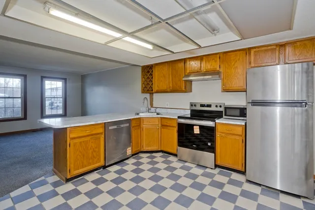 a kitchen with stainless steel appliances granite countertop a refrigerator and a stove top oven