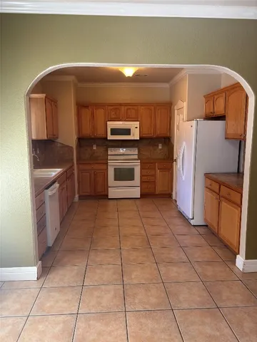a kitchen with a stove top oven and cabinets