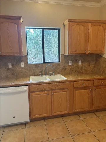a kitchen with granite countertop sink and cabinets