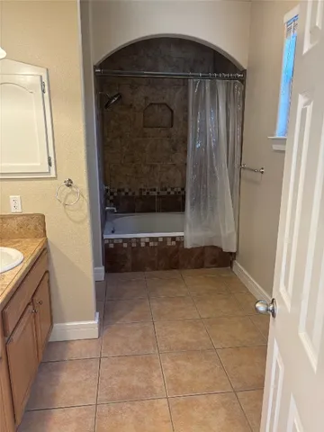 a bathroom with a tub shower and vanity