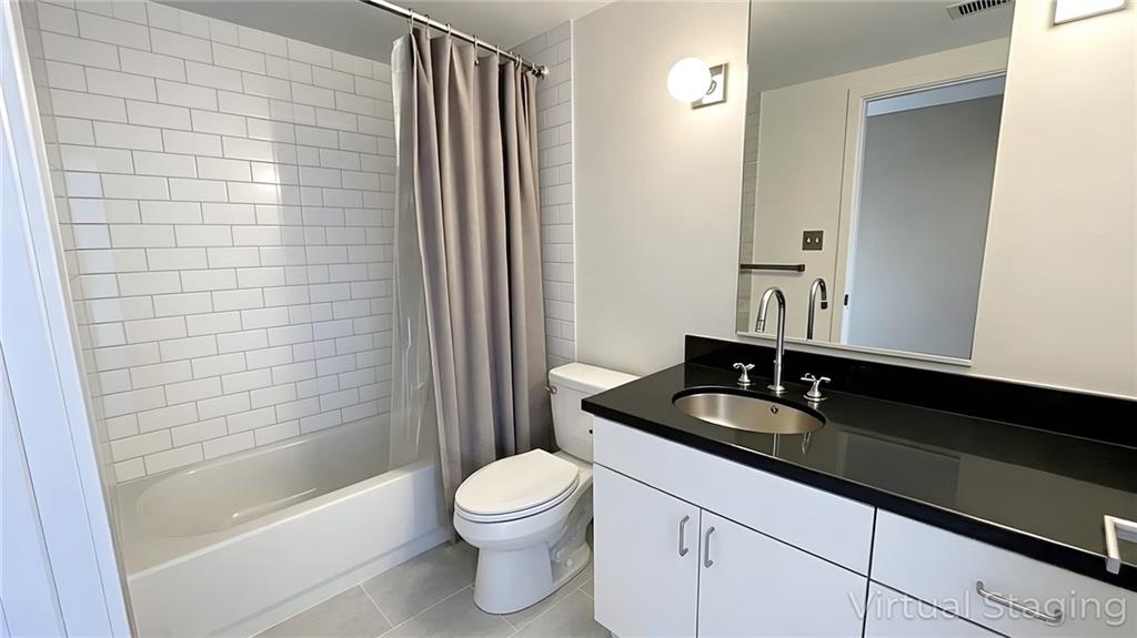 850 Ralph McGill Boulevard Northeast, Unit 30 Atlanta, GA 30306 - Photo 15 of 21 a bathroom with a granite countertop sink toilet a mirror and shower