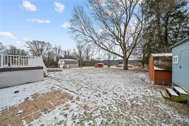 a view of yard covered with snow in front of house