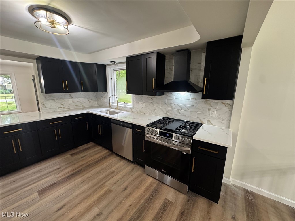 4018 Root Road North Olmsted, OH 44070 - Photo 9 of 23 Kitchen featuring wall chimney exhaust hood, appliances with stainless steel finishes, dark cabinets, and plenty of natural light