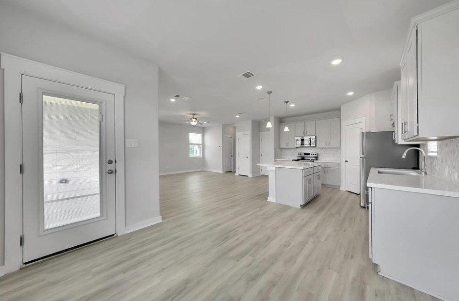300 Old Trinity Way Georgetown, TX 78628 - Photo 15 of 16 Kitchen featuring light countertops, open floor plan, a kitchen island, hanging light fixtures, and light wood-style floors
