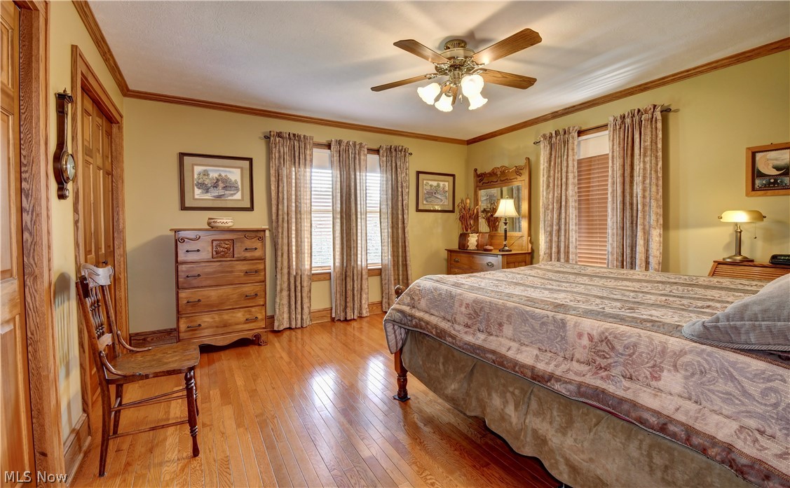 3464 Ridge Road Northwest Strasburg, OH 44680 - Photo 17 of 49 Bedroom featuring ceiling fan, light hardwood / wood-style flooring, and ornamental molding
