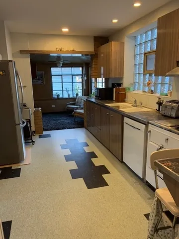 a kitchen with stainless steel appliances granite countertop a sink a stove and a refrigerator