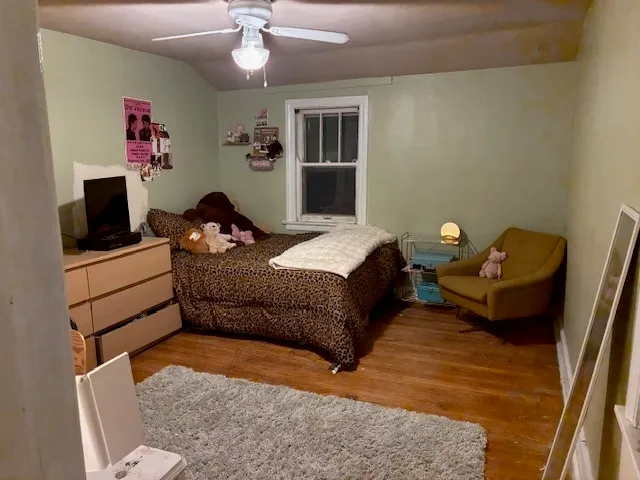 a bedroom with a bed and wooden floor