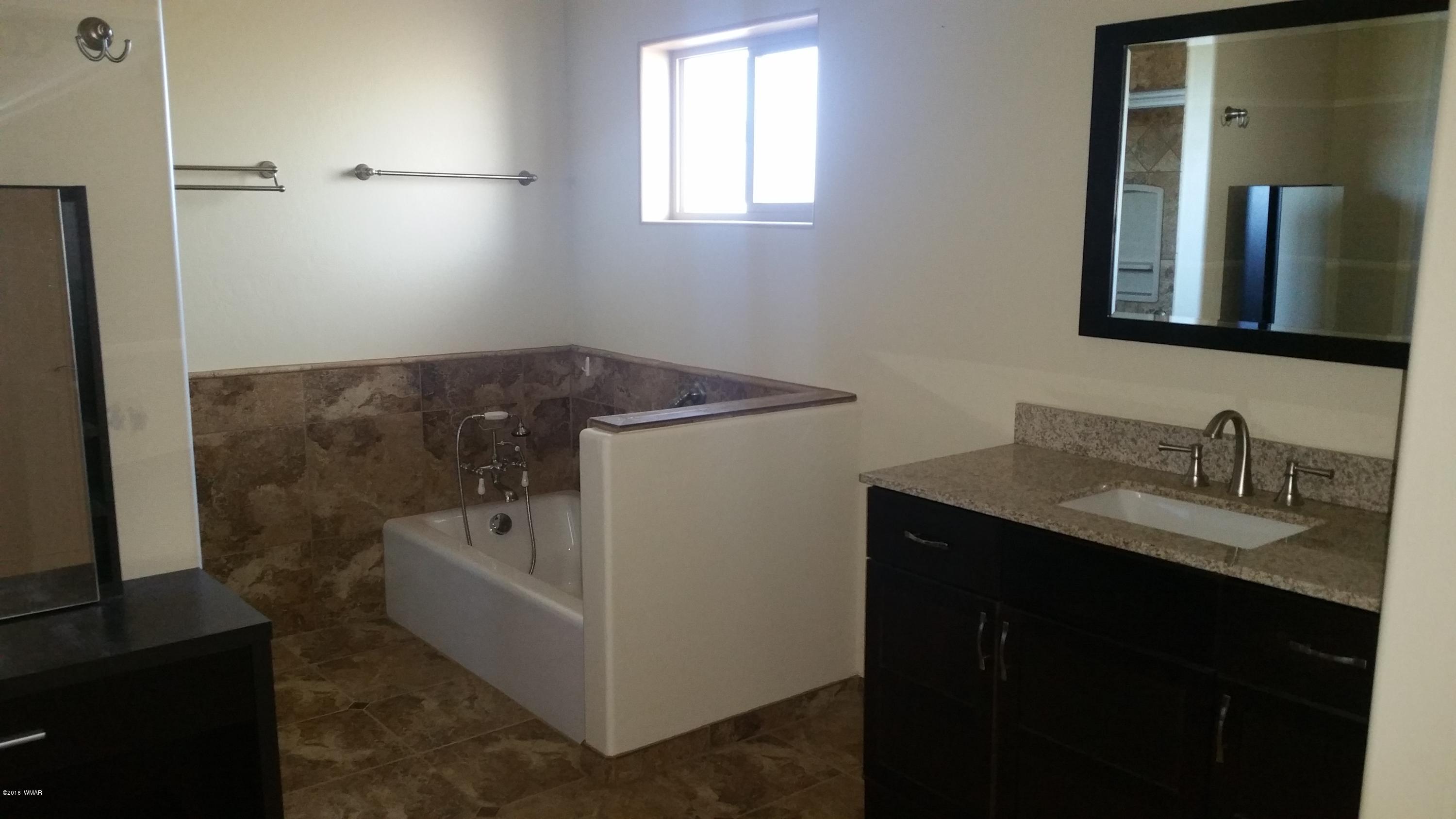 5139 Garibaldi Road Snowflake, AZ 85937 - Photo 29 of 39 a bathroom with a granite countertop sink and a mirror