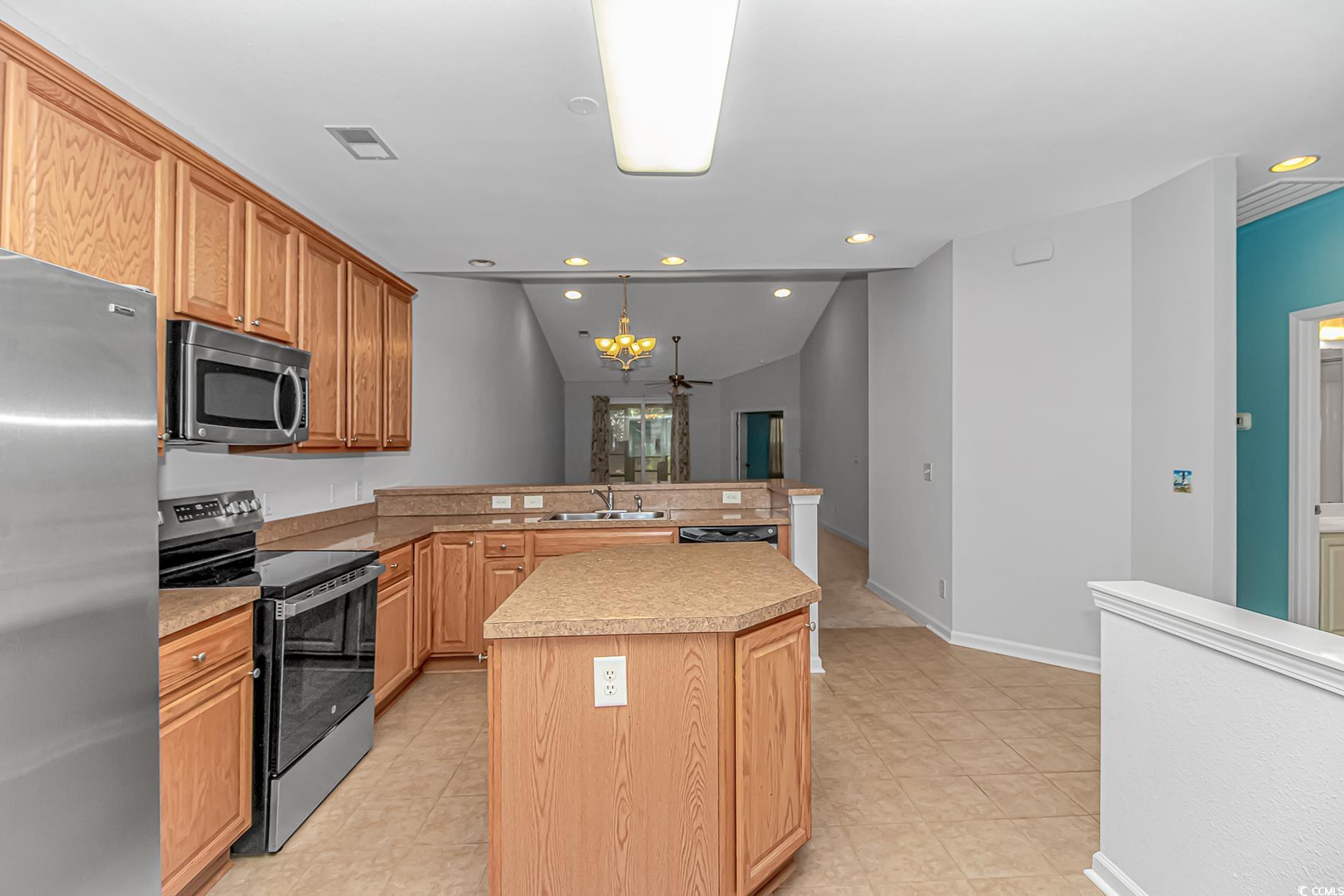 139 Chenoa Drive, Unit D Murrells Inlet, SC 29576 - Photo 7 of 34 Kitchen with stainless steel appliances, a peninsula, light countertops, vaulted ceiling, and hanging light fixtures