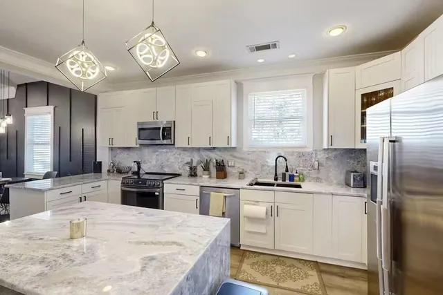 a kitchen with refrigerator cabinets and a sink