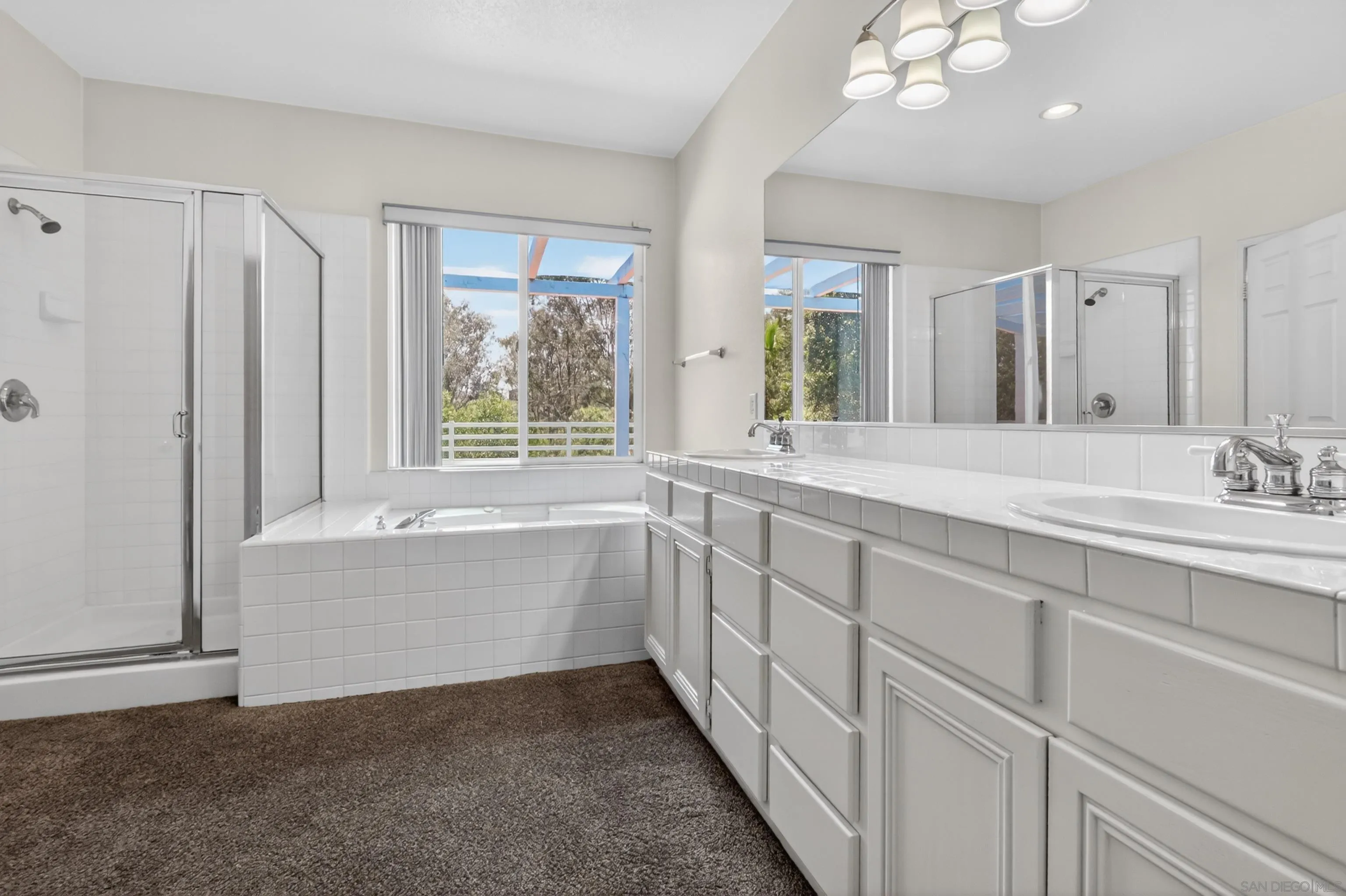 1432 Belmont Park Road Oceanside, CA 92057 - Photo 42 of 54 a bathroom with a double vanity sink a bathtub and next to a window