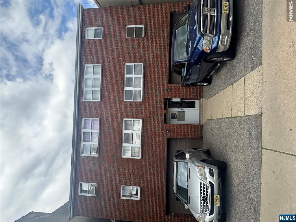 399 Walker Street, Unit 1B Fairview, NJ 07022 - Photo 1 of 11 a car parked in front of a building