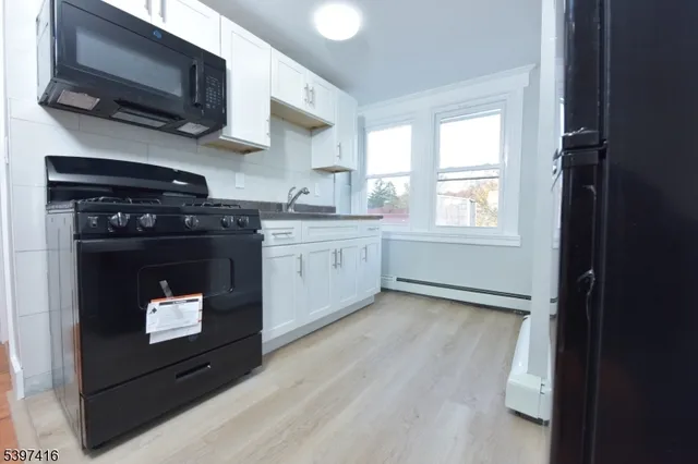 a kitchen with stainless steel appliances granite countertop a stove a microwave and a sink