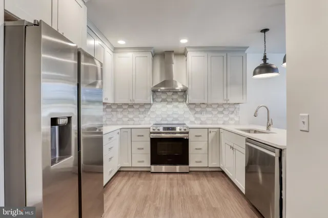 a kitchen with stainless steel appliances granite countertop a stove a sink and a refrigerator