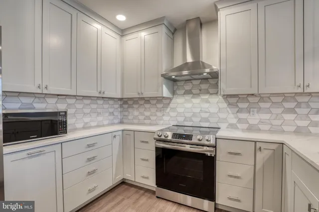a kitchen with granite countertop white cabinets and stainless steel appliances