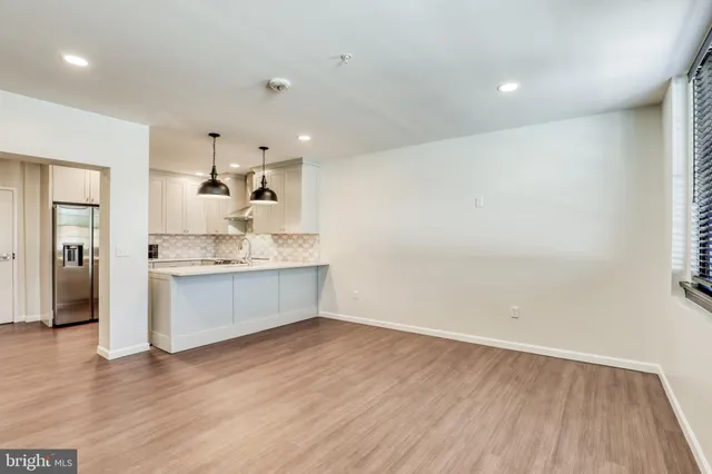 a large white kitchen with a white wooden cabinets and wooden floor