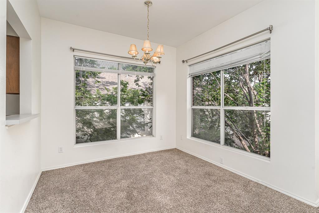 3329 Rosedale Avenue, Unit 21 University Park, TX 75205 - Photo 7 of 24 Carpeted spare room with a chandelier and healthy amount of natural light